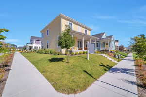 View of front of property with covered porch and a front yard