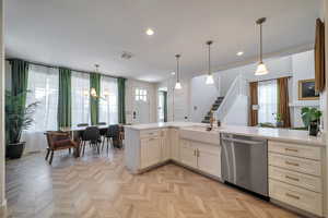 Kitchen with hanging light fixtures, dishwasher, and sink