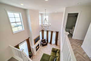 Living room with a notable chandelier, a fireplace, plenty of natural light, and light parquet floors