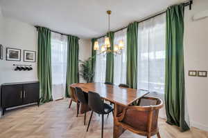 Dining room featuring light parquet floors and a chandelier