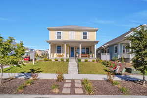 View of front facade featuring a front lawn and covered porch