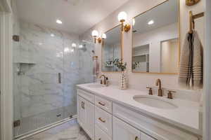 Bathroom featuring vanity and a shower with door