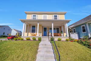 View of front of house featuring a front lawn and a porch