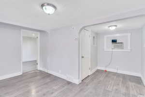 Spare room featuring a textured ceiling and light hardwood / wood-style flooring