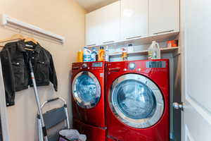 Washroom featuring cabinets, a textured ceiling, and separate washer and dryer