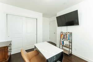 Guest bedroom with a closet and dark hardwood / wood-style floors