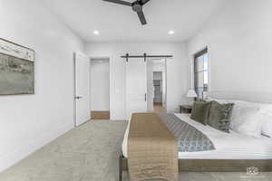 Bedroom featuring ceiling fan and a barn door