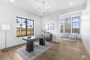 Office featuring wood-type flooring and a notable chandelier