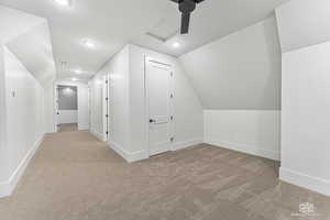 Additional living space featuring lofted ceiling and light carpet