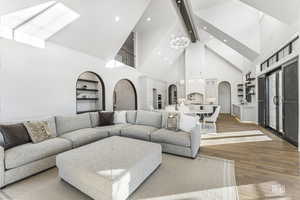 Living room with high vaulted ceiling and hardwood / wood-style floors