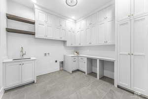 Clothes washing area featuring sink, cabinets, hookup for a washing machine, and electric dryer hookup