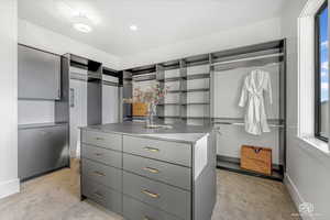 Walk in closet with light colored carpet