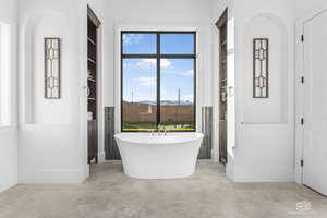 Bathroom featuring a tub to relax in and built in shelves