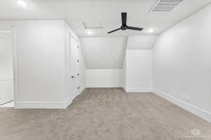 Bonus room featuring vaulted ceiling and light carpet