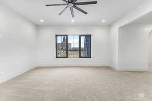 Empty room featuring ceiling fan and light carpet