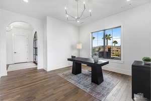 Office space featuring dark hardwood / wood-style flooring and an inviting chandelier