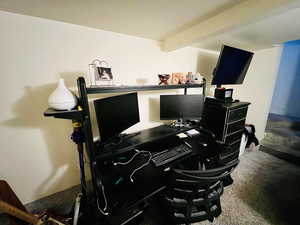 Carpeted office space with beamed ceiling