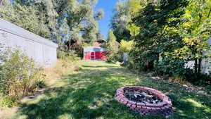 View of yard featuring a shed and an outdoor fire pit