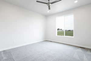 Carpeted spare room featuring ceiling fan