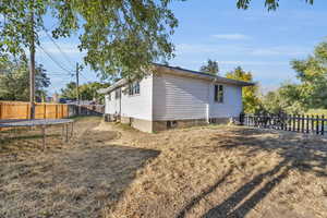 View of side of property with cooling unit and a trampoline