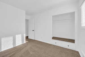 Unfurnished bedroom with a closet and carpet flooring