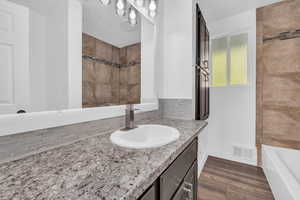 Bathroom featuring vanity, bathing tub / shower combination, tasteful backsplash, and hardwood / wood-style flooring