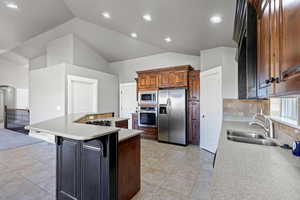 The kitchen features rich wood cabinetry, stainless steel appliances, and ample counter space