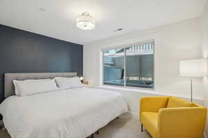 Carpeted bedroom with a textured ceiling