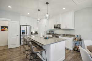 Kitchen featuring white cabinets, sink, decorative light fixtures, high quality appliances, and dark hardwood / wood-style flooring