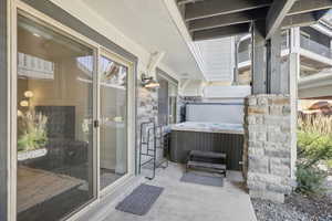 View of patio featuring a balcony and a hot tub