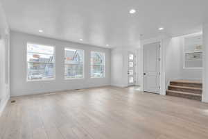 Unfurnished living room with a wealth of natural light and light wood-type flooring