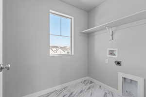 Clothes washing area with hookup for an electric dryer, washer hookup, and plenty of natural light