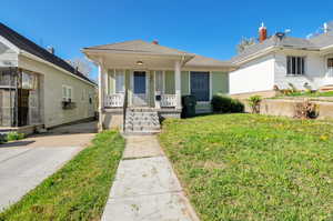 Bungalow-style home featuring a front lawn and covered porch