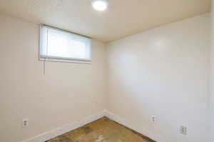 Empty room with concrete flooring and a textured ceiling