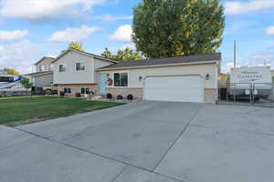 Tri-level home featuring a front yard and a garage