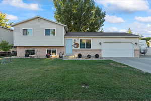 Tri-level home with a front yard and a garage