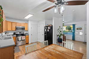 Kitchen featuring a textured ceiling, light hardwood / wood-style floors, sink, appliances with stainless steel finishes, and ceiling fan