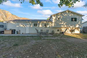 Back of property with a patio and a mountain view