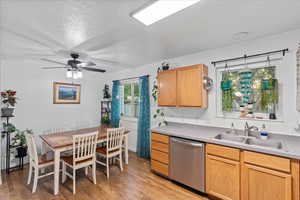 Kitchen featuring light hardwood / wood-style flooring, dishwasher, a textured ceiling, and sink