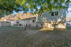 Back of property with a mountain view and a patio area