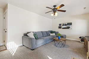 Living room featuring ceiling fan and carpet flooring