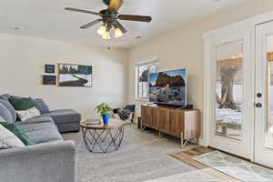 Living room featuring ceiling fan, hardwood / wood-style flooring, and a textured ceiling