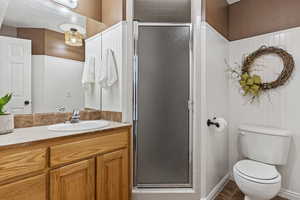 Bathroom with vanity, toilet, tile patterned floors, and a shower with shower door