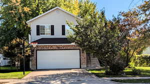 View of property featuring a front lawn and a garage