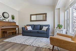 Living room with LVP / wood-style flooring and lofted ceiling