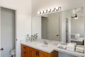 Bathroom with ceiling fan, vanity, and separate toilet room