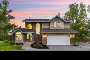 View of this wonderful home featuring a lovely yard and two-car garage