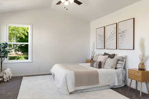 Primary bedroom featuring vaulted ceiling and ceiling fan