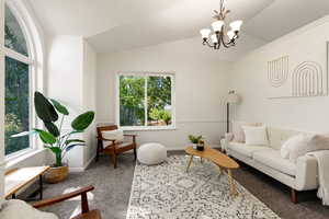 Front sitting room featuring lofted ceiling, a chandelier, and carpet with wonderful natural light