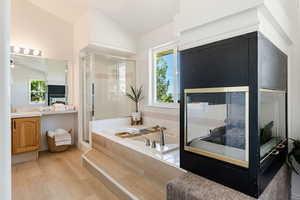 Bathroom featuring walk-in shower, lofted ceiling, ceiling fan, and vanity